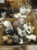 A box containing various cat figurines and a box containing assorted cat doorstops,