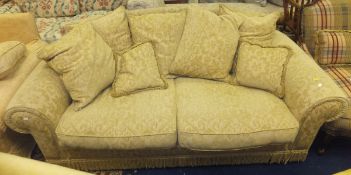 A two seater sofa in gold foliate self patterned upholstery,