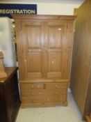 A pine two door wardrobe on a chest of two short and two long drawers to bracket feet