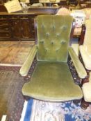 An Edwardian button back armchair in green velour upholstery and exposed mahogany frame,