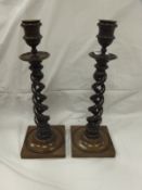 A pair of circa 1900 rosewood open barley-twist candlesticks with brass sconces