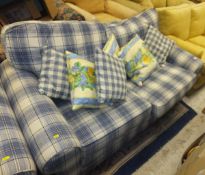A two seater sofa bed and single armchair in a blue and white tartan upholstery