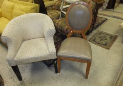 A modern cream upholstered tub chair raised on square tapered legs,