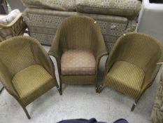 A pair of Lloyd Loom gold painted tub chairs, together with another similar,