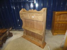 A pine two shelf wall hanging unit with two drawers below,