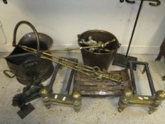 A cast iron grate on two iron and brass dogs, a 19th Century brass coal bucket,