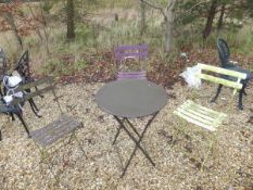 A modern painted metal folding bistro style table and three chairs and a further table and two