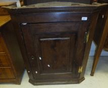 A 19th Century oak hanging corner cupboard with single panelled door opening to reveal shelving
