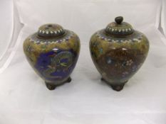A pair of Chinese cloisonné ovoid lidded pots on three footed bases with three panels to the body,