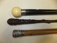 An early 20th Century walking cane with white metal ferule and ivory ball knob,