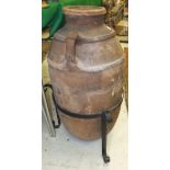 A Greek terracotta amphora with two ribbed bands united by the side handles over a plain body,