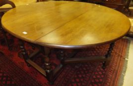 A mahogany oval gate-leg dining table with baluster turned and ringed legs