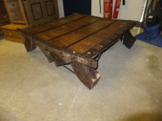 An Eastern hardwood low coffee table with various decorative iron bindings, bars, hoops,