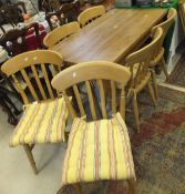 A modern pine farmhouse style kitchen table and a set of six stained beech slat back kitchen chairs