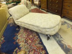 An Edwardian mahogany framed day bed in pale yellow ground foliate patterned upholstery with