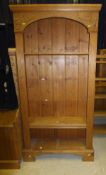 A pine open bookcase with adjustable shelves, arched top and moulded decoration,