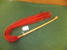 A fly swish with dyed red horse hair