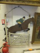 A vintage painted metal two sided sign depicting a rider and horse jumping gate