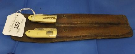 A pair of cased cut throat ivory handled razors in a brown leather case