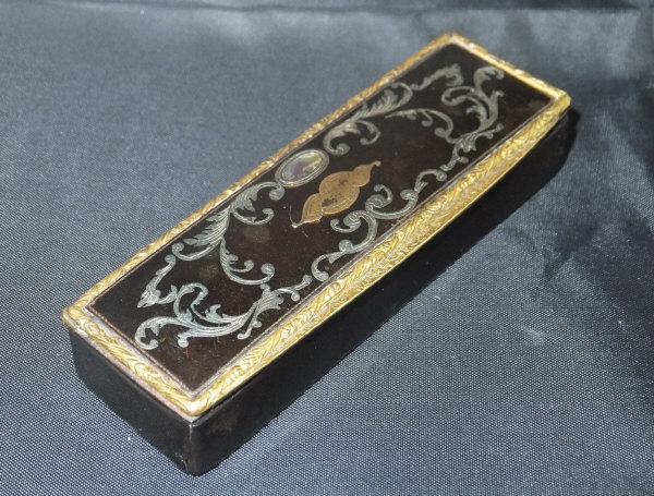 An early 19th Century tortoiseshell snuff box of rectangular form inlaid with silver,