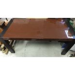 A black ash and chocolate lacquered dining table on rectangular supports