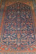 A Caucasian rug, the central dark blue ground with stylised motifs in salmon, red,