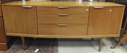 A 1960's Scandinavian teak shallow bow fronted sideboard with three central graduated drawers