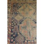 A rug with central twin lozenge medallion on a navy and terracotta ground with animal and floral