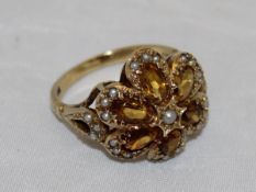 A 9 carat gold citrine and seed pearl mounted dress ring in the form of a flower head