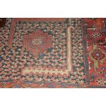 A Caucasian rug, the central medallions in red, blue, amber and green,