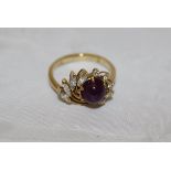An 18ct gold ruby and diamond floral burst cluster ring with a central cabouchon cut star ruby,