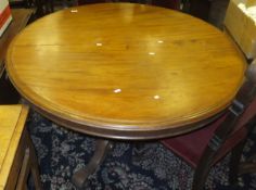 A Victorian mahogany breakfast table, the circular top raised on a tapering pedestal to tripod base,