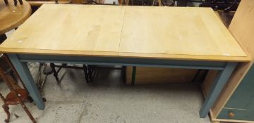 A beech topped rectangular extending dining table with teal painted base