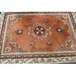 A Chinese carpet, the central blue and cream medallion on a salmon ground, within cream,