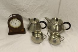 A Roundhead pewter four piece tea set and a mahogany and inlaid dome topped mantel clock