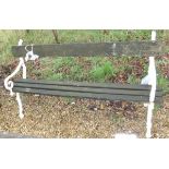 A garden bench, the painted wrought iron ends in the form of stylised branches,