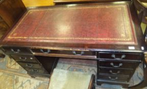 A mahogany effect pedestal desk of nine drawers with red leatherette inset top,