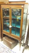 An Edwardian mahogany Sheraton revival display cabinet with two astragal glazed doors enclosing