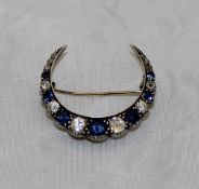 A Victorian sapphire and diamond three-quarter crescent brooch set with nineteen graduated stones,