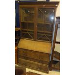 An oak bureau bookcase with dentil carved cornice,