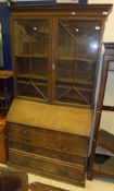 An oak bureau bookcase with dentil carved cornice,