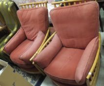 Two Ercol armchairs with terracotta upholstered seats and backs,