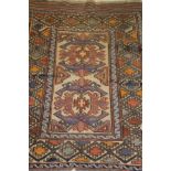 A Kelim rug with wool pile decoration in terracotta, blue, amber and pale red on a taupe ground,