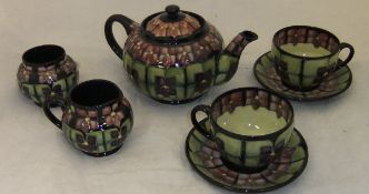 A Moorcroft tête à tête tea set in the "Violet" pattern, designed by Sally Tuffin,