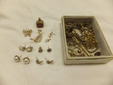 A collection of gold and yellow metal jewellery to include a seal pendant, various earrings,