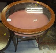 An oval glass topped bijouterie table on slender square sectioned legs,