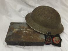 A box containing a collection of First World War memorabilia to include regimental badge,