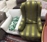 A wing back armchair in lime green and olive green striped upholstery,