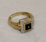 A gold mounted square set dress ring with four central sapphires within a band of illusion set