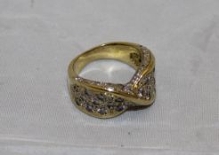 An un-marked gold and diamond set dress ring in the form of a stylised bow